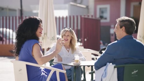 Group of Friends Laughing and Talking at an Outdoor Cafe Table