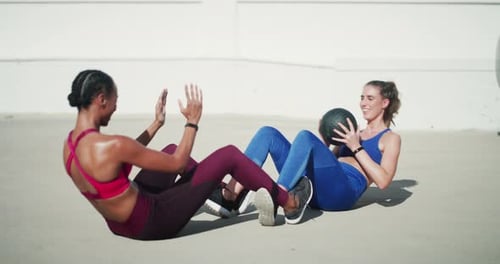 Young Women Working Out Together Doing Sit Ups