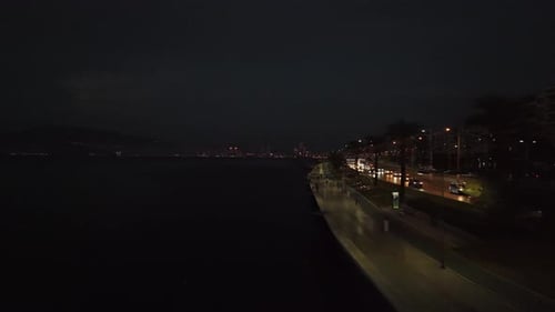 Night Coastal Cityscape with Traffic and Walking Path