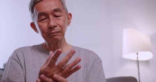 Senior Massages Hand to Relieve Pain