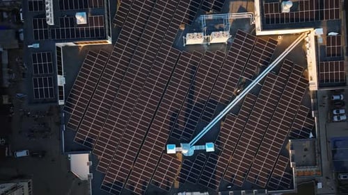 Aerial drone view of solar panels at sunset. Photovoltaics on top of the roof of the building. Alter