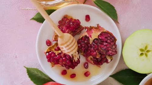 Verter miel en la comida tradicional para la festividad del Año Nuevo judío de Rosh Hashaná con granada y