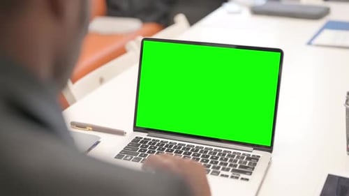African Man Working on Laptop with Green Screen