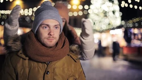Affectionate young couple hugging at christmas market