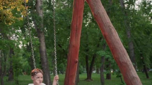 Joyful Summer Swing Scene of Boy Playing in Park Under Warm Dusk Light