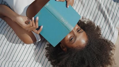 Beach Girl Reading Book Lying on Blanket Closeup