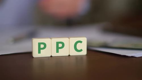 Concept of Pay Per Click advertising. PPC initials with selective focus and money on the background
