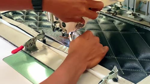 Hands threading an automatic sewing Textile industry.