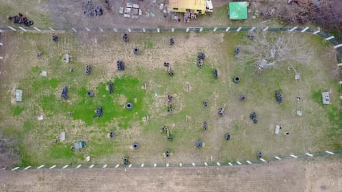 Drohnenaufnahme von Paintball-Spielern, die auf dem Spielfeld eine Partie Paintball spielen.
