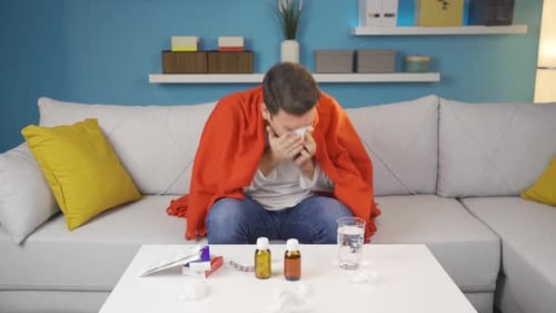 Le jeune homme malade est assis chez lui, fatigué et épuisé.