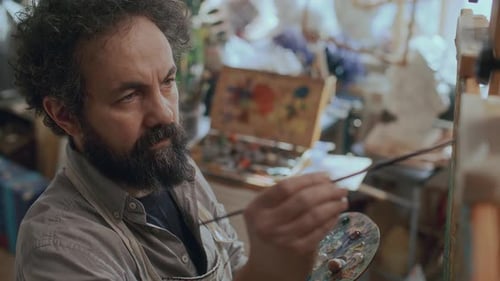 Focused Male Painter Working on Artwork in Creative Studio