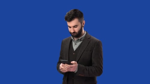 Smiling Business Man Chatting Browsing Internet Use Smartphone Isolated on Blue Screen Chroma Key