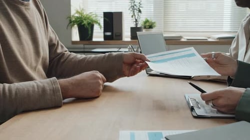 Close Up Of Caucasian Man Giving Document To Caucasian Colleague