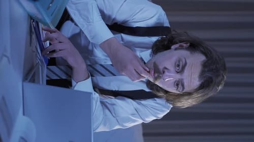 Stressed Man Works Late in Blue-Lit Office