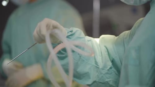 Medical Professional Manipulates Needle and Tubing Close Up