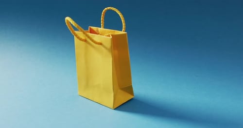 Bolsa de regalo amarilla con asas de cordón sobre fondo azul