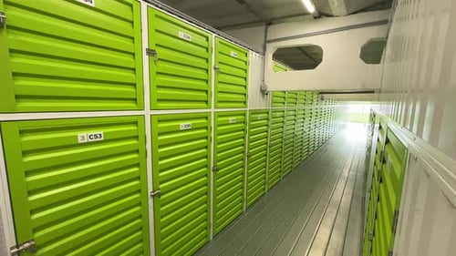 Unités d'entreposage en libre-service d'un vert éclatant dans un couloir bien éclairé