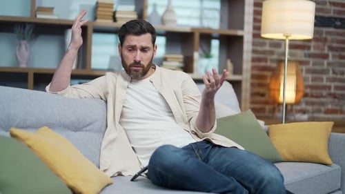 Worried Man Sitting on Couch Indoors