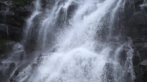 Zeitlupenaufnahmen von Wasser, das von einem Wasserfall fällt.