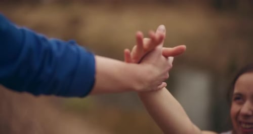 Person Holding Child's Hands in Nature