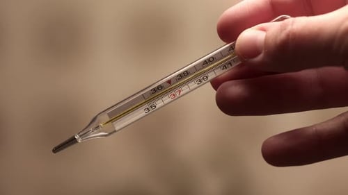 Mulher segura termômetro de mercúrio nas mãos para medir a temperatura corporal, médico ou enfermeira