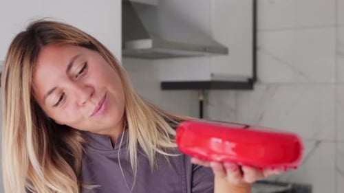 Woman Smiles Holding Glossy Red Glazed Dessert