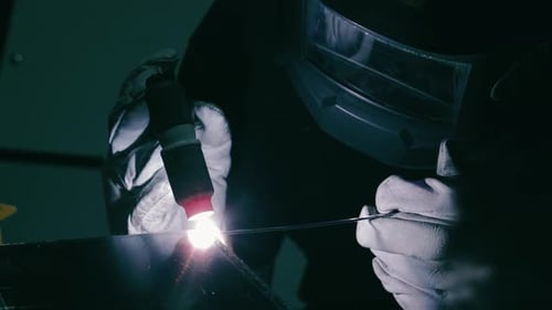 Focused Welding with Protective Helmet A Closeup of a Welder Wearing a Protective Helmet Carefully