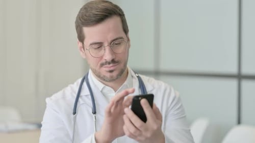 Doctor Using Smartphone in Hospital Setting