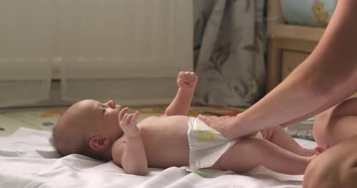 Madre cambiando los pañales de su bebé