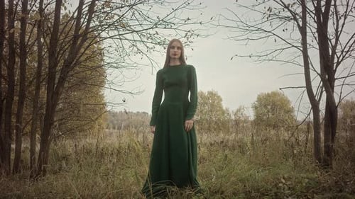 Model posing wearing green dress in autumn nature
