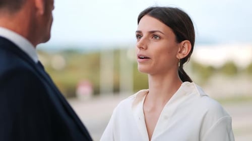 A young businesswoman has a business conversation with her older colleague outside