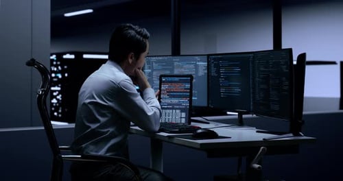 Focused Adult Working with Computer and Tablet