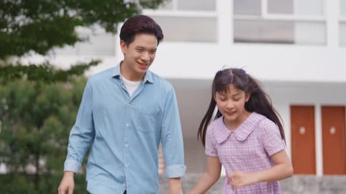 Asiatisch liebender Vater geht mit seiner kleinen Tochter draußen im Garten spazieren.