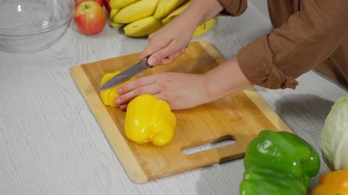 Preparing Healthy Meal, Cutting Yellow Pepper on Board