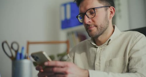 Businessman Texting Through Smart Phone at Office