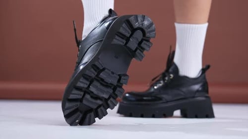 Black modern leather shoes on thick tractor soles. Comfortable footwear combined with white socks