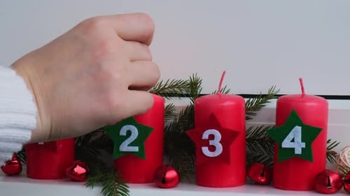 Traditionelle vier Adventswochen vor den Weihnachtsfeiertagen, rote Kerzen mit brennenden Zahlen und Kunststoff