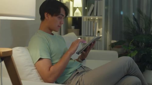 Man Using Tablet on Couch at Home