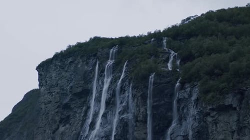 The Seven Sisters waterfall cascades down a steep cliff into the Geiranger Fjord in Norway