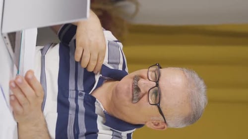 Vertical video of Home office worker old man is disgusted.