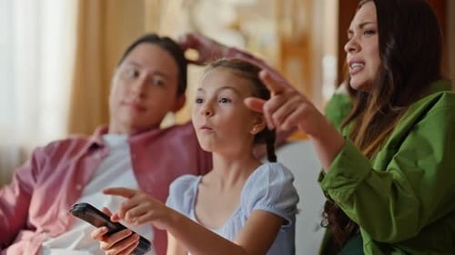 Cute Child Switching Channels Watching Cinema Together with Parents Closeup