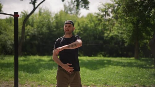 Man Stretching Arms Before Workout in the Park