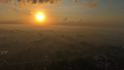 A Sunrise Over A Misty Village Landscape