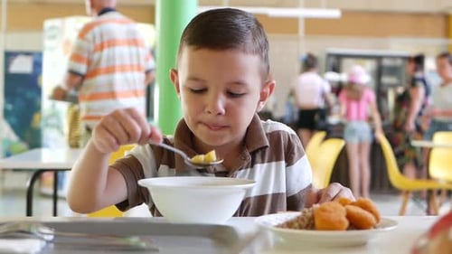 Boy Eating Lunch in School Cafeteria