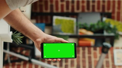 Employé de bureau vidéo vertical analysant un smartphone avec un modèle d'écran vert
