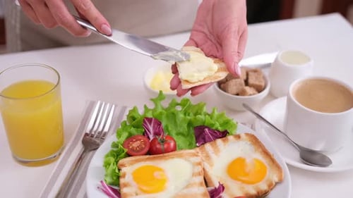 Woman Spreading Butter on Toast at Breakfast