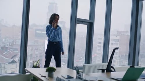 Elegant Businesswoman Speaking Smartphone Stepping at Office Panoramic Window