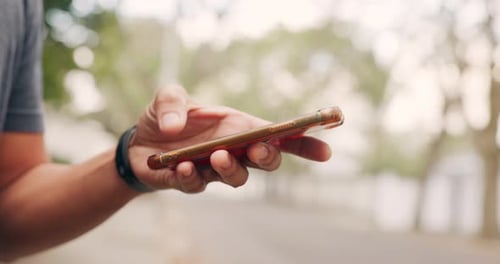 Hand Using Smartphone on Urban Street