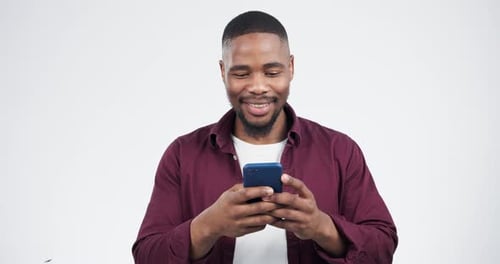 Phone, message and black man laugh in studio for funny, post or social media post on grey