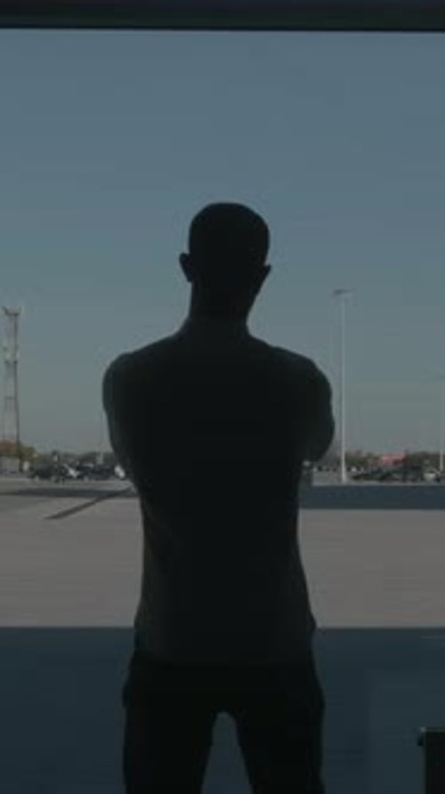 Silhouette of a Businessman Back Overlooking the Parking Space Behind the Window HDR Rear View of a